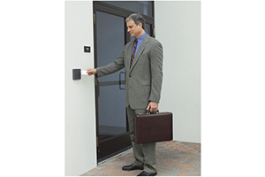 man scanning a badge on an access control device